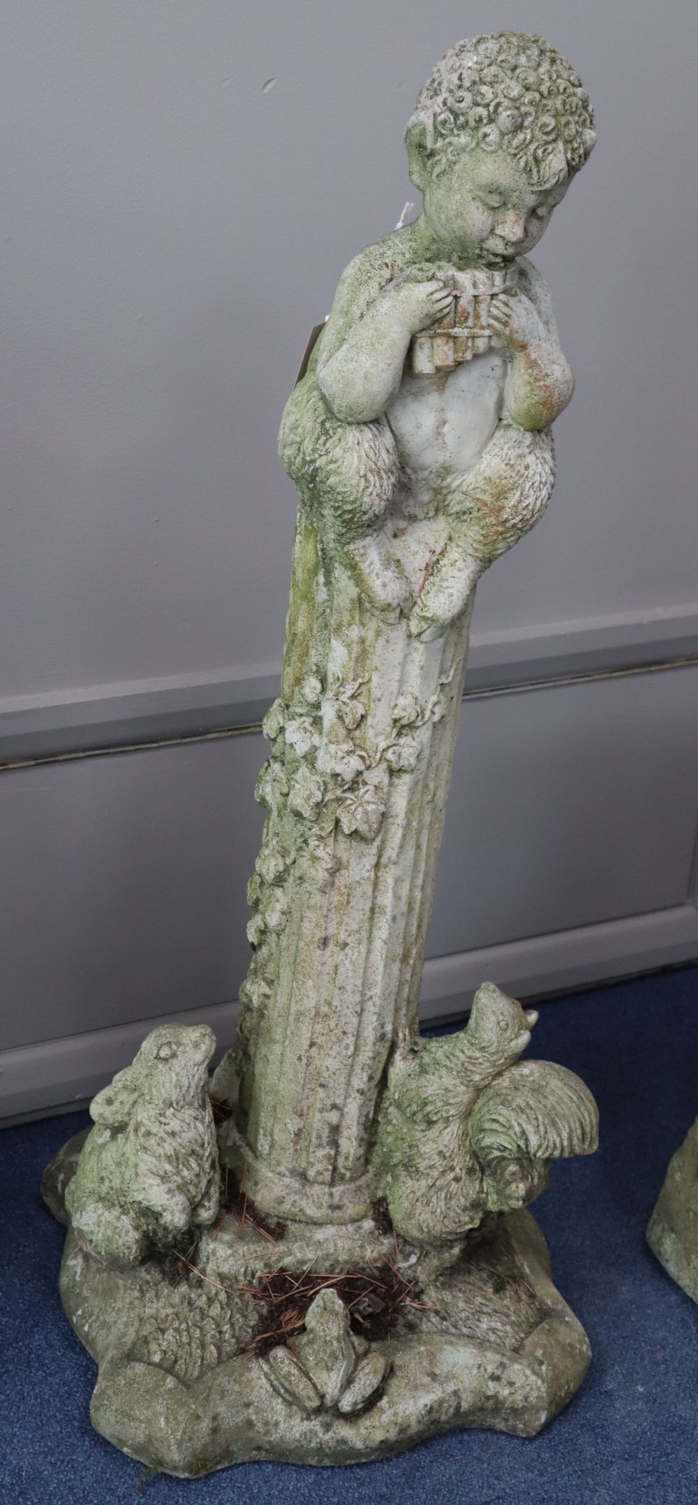 A reconstituted stone garden figure of Pan on fluted column, H.84cm